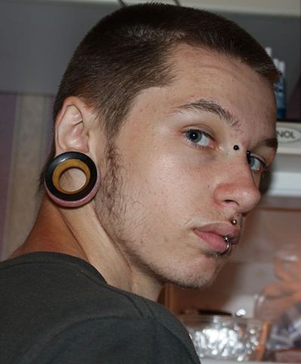 Ein junger Mann mit Ear Plugs - gedehnten Ohrläppchen