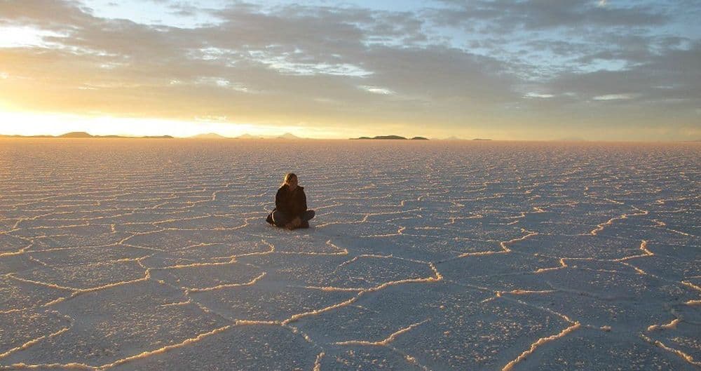 Praktikum in La Paz: Von hier aus hat man die Chance die ganze Vielfalt Boliviens zu erkunden. Wie zum beispiel am Sal de Uyuni. Hier sitzt Sarah im Schneidesitz und schaut in den Sonnenuntergang.