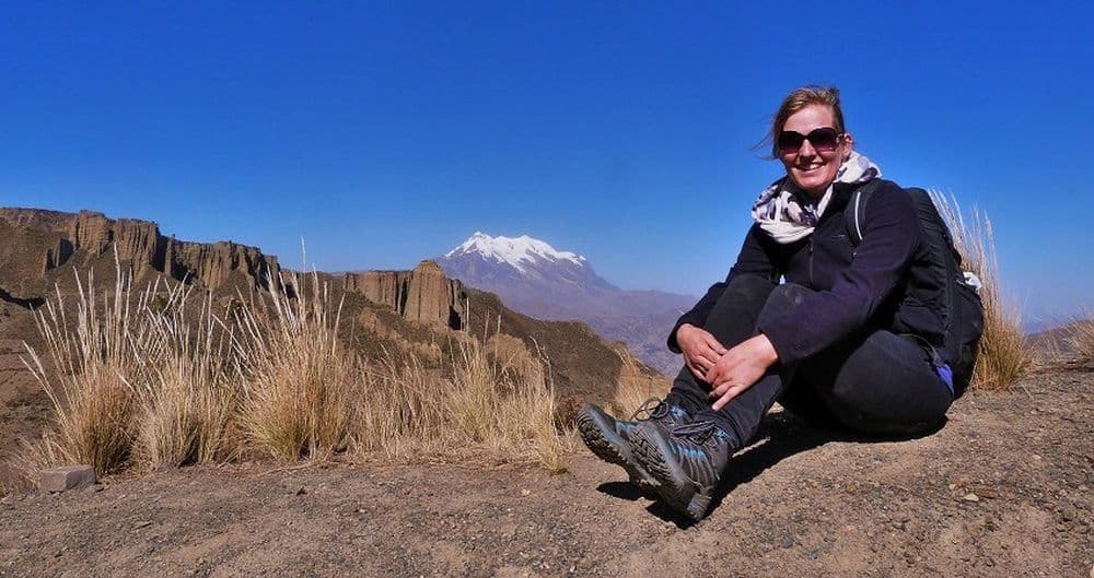 Praktikum in La Paz: Sarah ist bereits seit vier Monaten in Bolivien. Bisher hat sie schon viel erlebt und hat auch für die folgende Zeit noch viel vor. Hier sitzt sie auf einem Felsen während eines Ausfluges in der Nähe von La Paz. Im Hinergrund leuchtet der schneebedeckte Illimani Berg