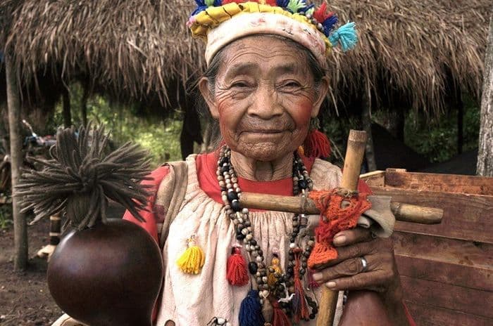 Indigene Völker im Amazonasgebiet: Die Guarani Großmutter trägt viel Schmuck und präsentiert ihre Musikinstrumente.